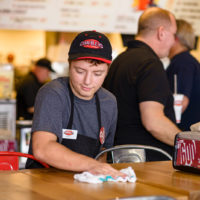 Charleys franchise employee wiping down table